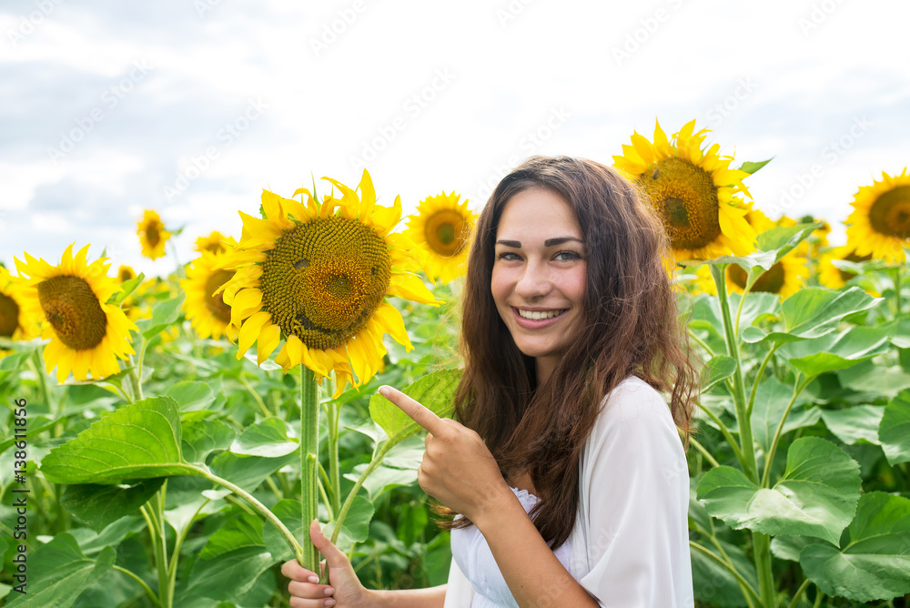 cheerful girl standing in a sunflower field cheerful girl standing in a sunflower field