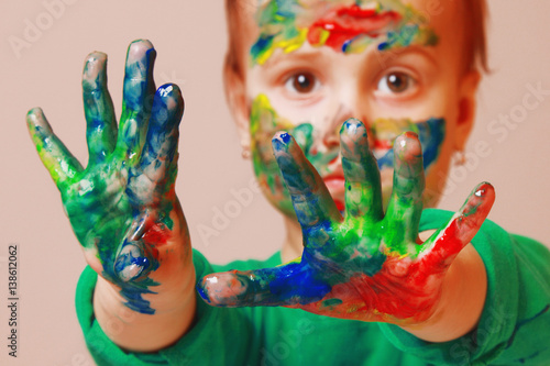 Happy cute little girl with colorful painted hands