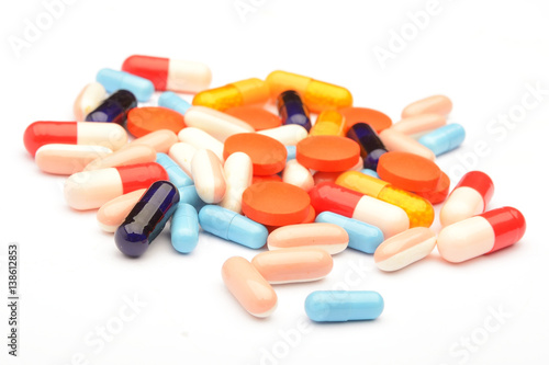 Colored pills, tablets and capsules on a white background