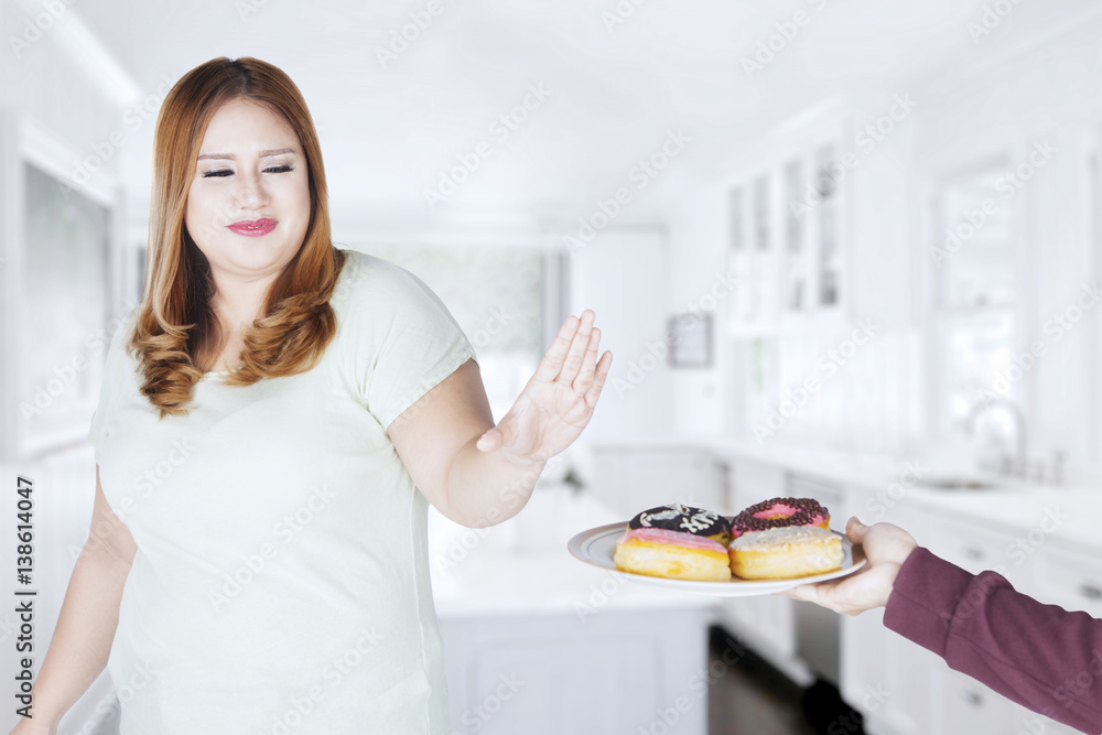 Beautiful woman refuses to eat donuts