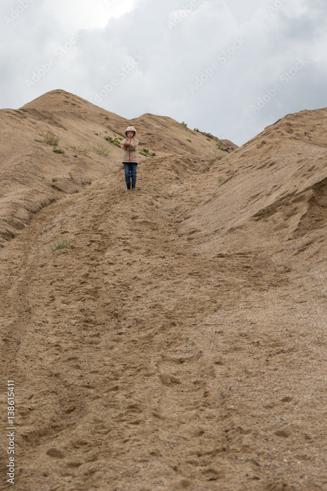 girl walking at sand quarry on rainy day