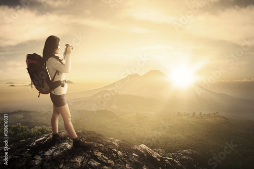 Female photographer takes photos in mountain peak