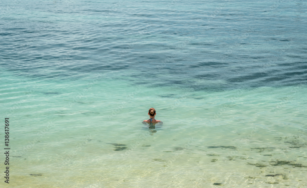 A beautiful woman relaxes immersed in the sea Alona Beach, Panglao, Philippines