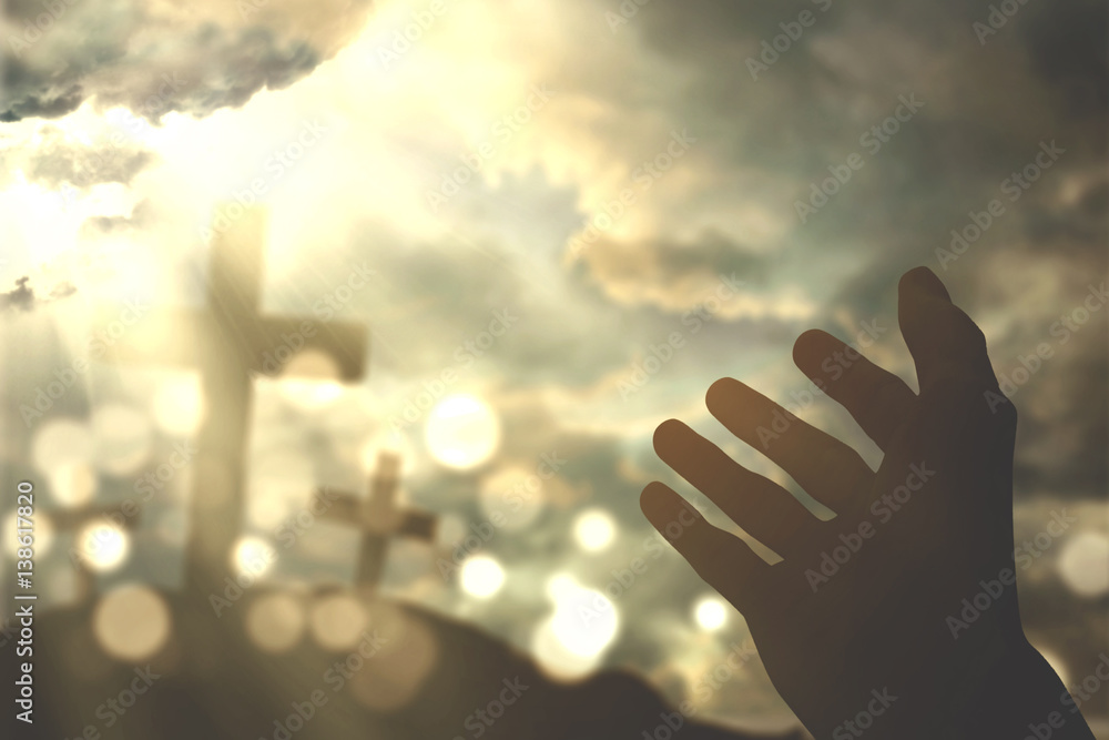 Human hands praying with cross symbol