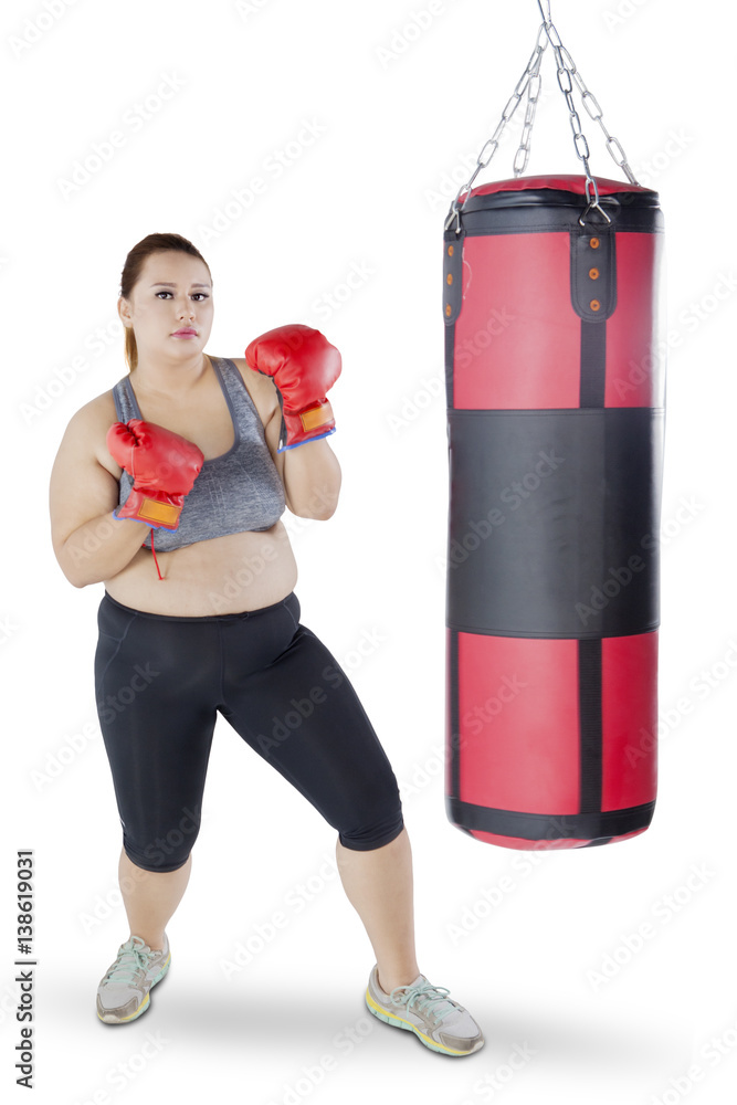 Overweight girl with boxing gloves and sack