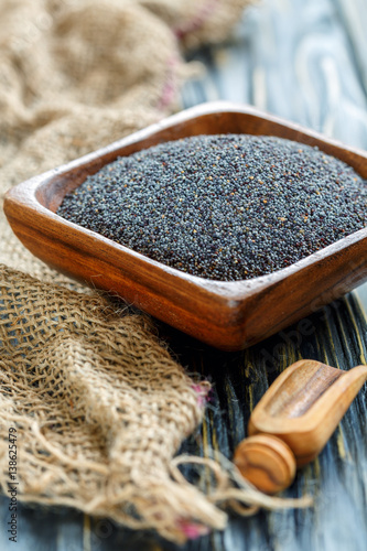 Poppy seeds in a square wooden bowl.