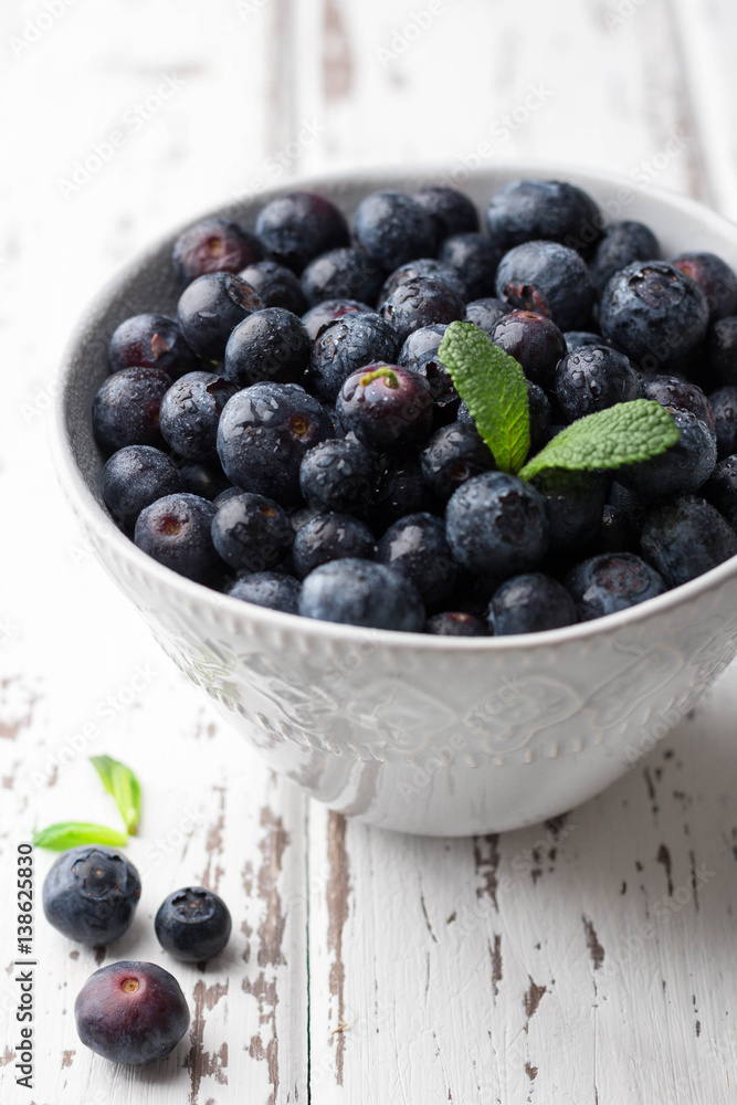 Fresh blueberries in bowl on light wooden background Fresh blueberries in bowl on light wooden background