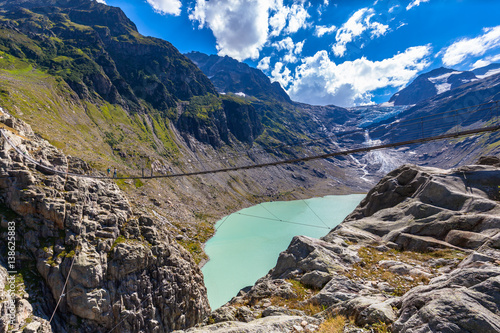 Stunning view of Trift bridge over the lake and glacier photo