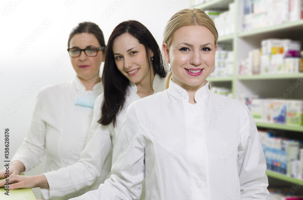 Professional female pharmacists portrait next to shelves Professional female pharmacists portrait next to shelves