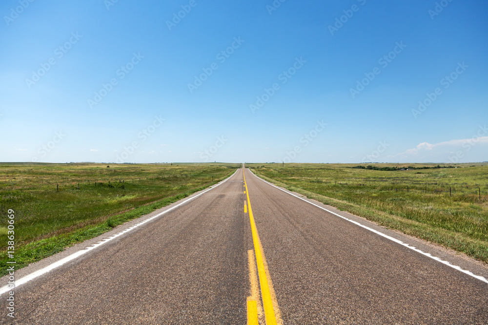 A road cutting through northern Nebraska on a summer day.