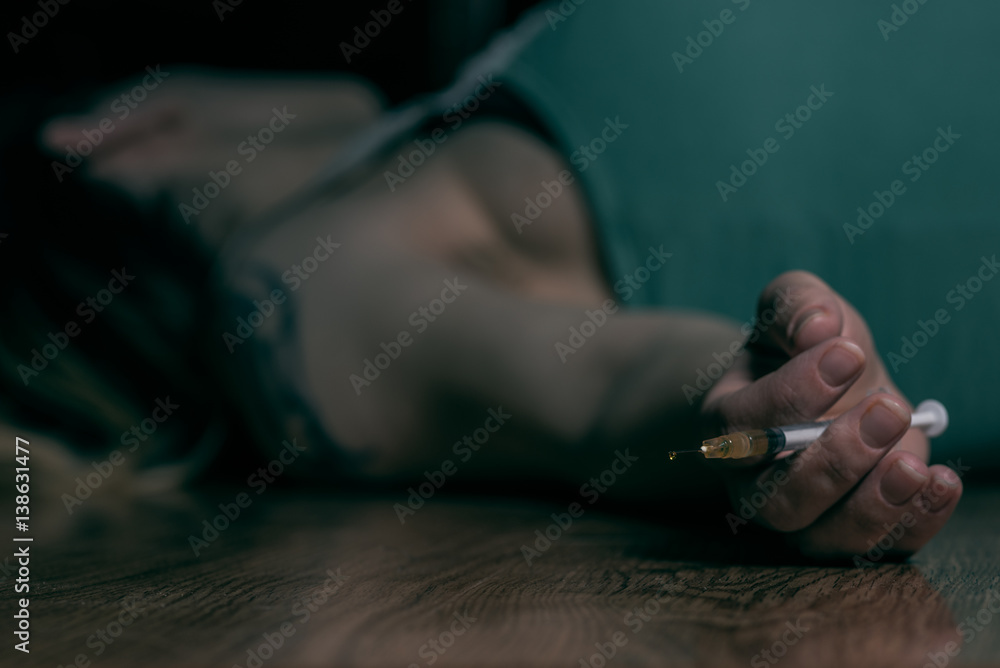 woman laying on the ground with needle in hand