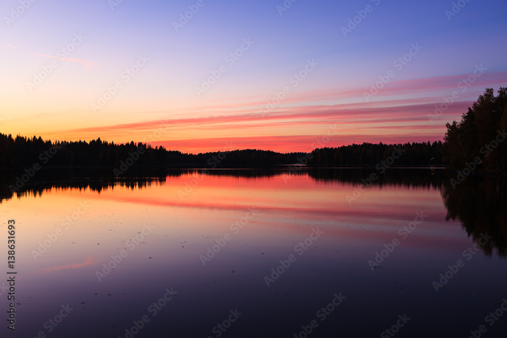 Serene view of calm lake and sunset clouds