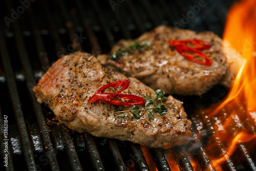 pork steak on bbq grill with flame