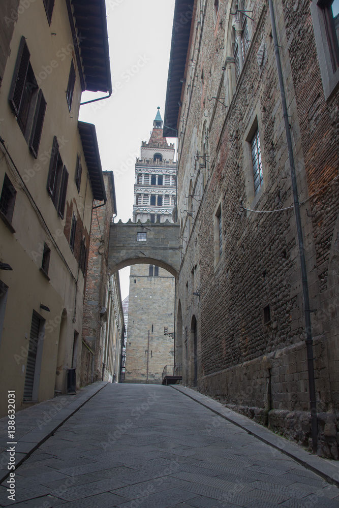 Ancient street and Campanile del Duomo di Pistoia on background. Tuscany. Italy.