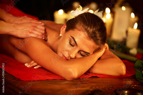 Massage therapy deals. Woman in spa salon. Girl on candles background treats problem back spa salon. Luxary interior with working masseuse in therapy salon. Female bare back with smooth skin relax .