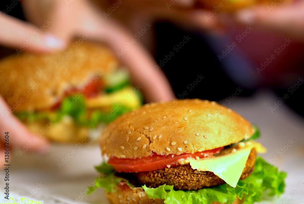New cooking of hamburger fast food with ham on wooden board . Group of hamburger. Human hand holding cheeseburger. Sharpness in front of sandwich. New cooking of hamburger fast food with ham on wooden board . Group of hamburger. Human hand holding cheeseburger. Sharpness in front of sandwich.