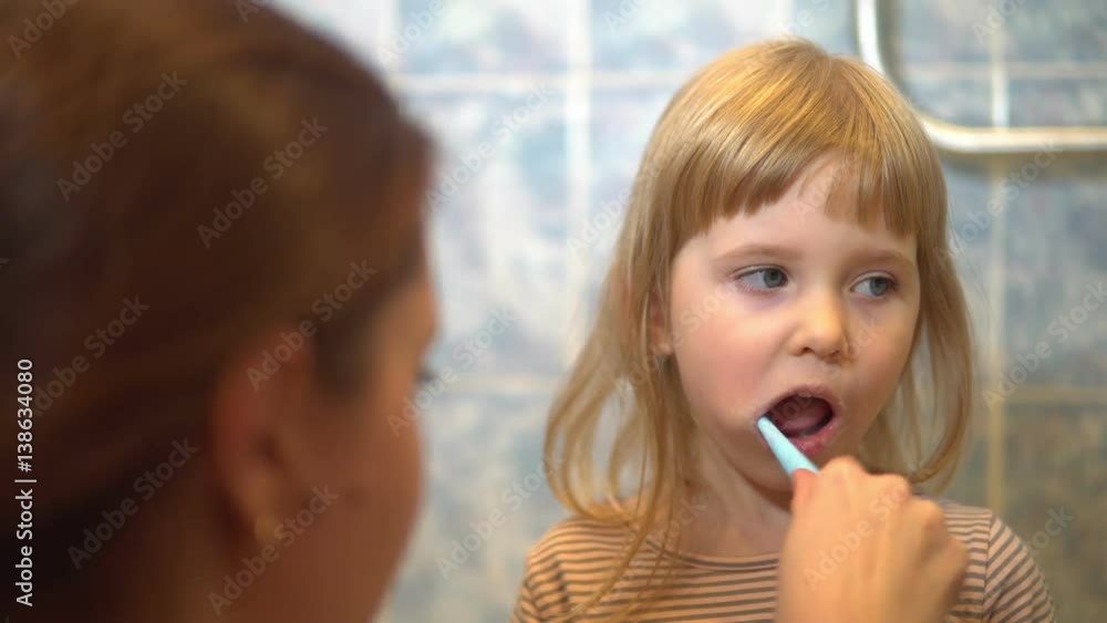 Mom daughter brushing teeth Mom daughter brushing teeth
