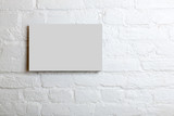 White blank poster in a white brick wall. Template Mock up for your content