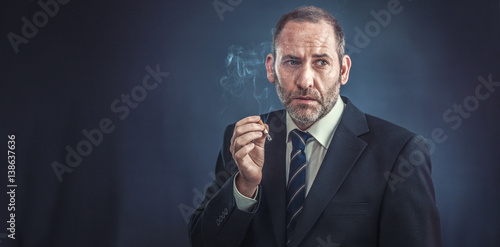 Cuadro en lienzo Mature Businessman smoking a cigarette