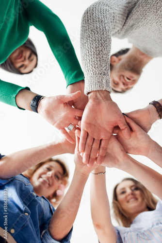 Photography Shot of a team of designers joining their hands together in unity
