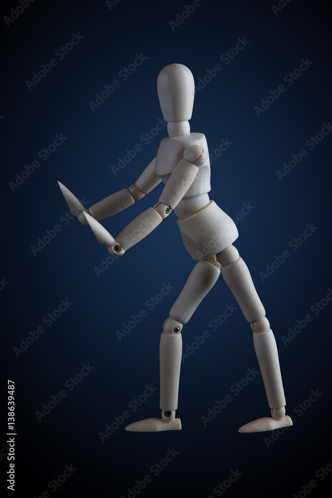 Wooden figurine in elegant dance move on dark background with blue spotlight Wooden figurine in elegant dance move on dark background with blue spotlight