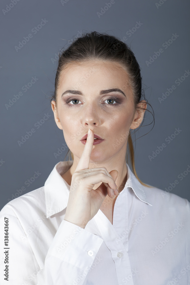business woman or secretary holds finger at mouth, silence symbol. Portrait
business woman or secretary holds finger at mouth, silence symbol. Portrait