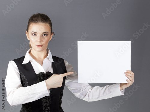
Beautiful sexy  woman with white poster on  gray background. Show your text
