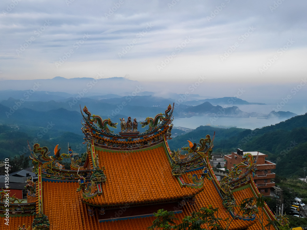 Traditional Chinese style roof in yellow with misty landscape seaview