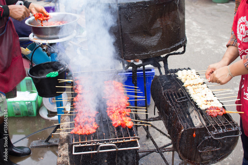 smoky food, smoke BBQ pork grill business sale at food stall rural market in Thailand. photo