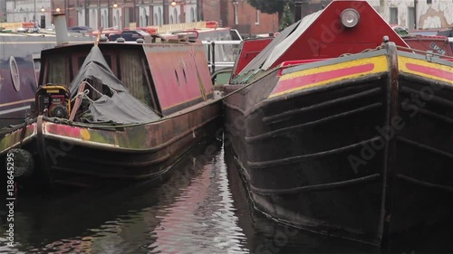 Tilt To Close Up of Narrow Boat Barges Docked in Canal Harbor