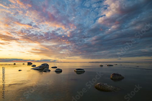 Baltic sea at beautiful sunrise,stony beach after storm
