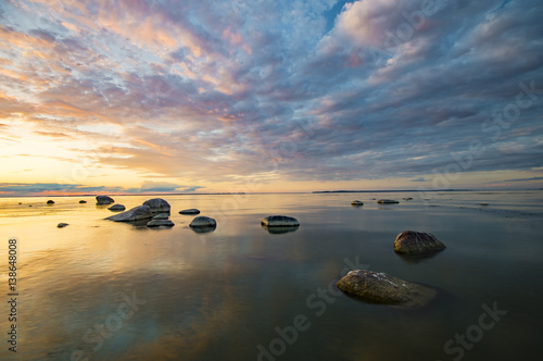 Baltic sea at beautiful sunrise,stony beach after storm