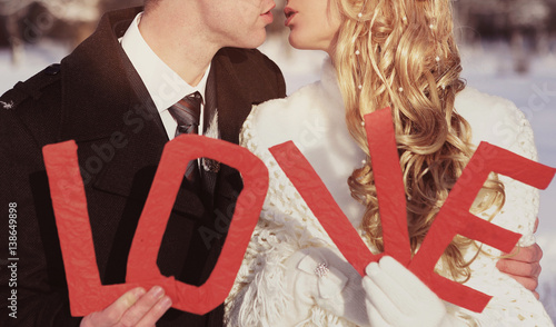 couple kissing on wedding day with letters word love photo