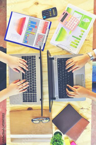 Wallpaper Mural Top view two business stuff with laptop computer on wooden background, sales report, pink and black calculator , brown notebook Business Concept Torontodigital.ca