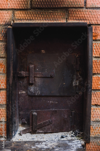 iron stove in the Russian bath lined with red brick photo