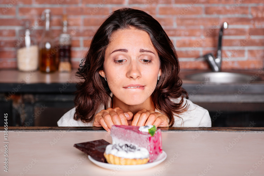 Woman on the diet craving to eat cake - obrazy, fototapety, plakaty 