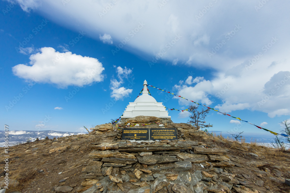 Buddhist stupa of enlightenment on the island Ogoy with flags. Baikal