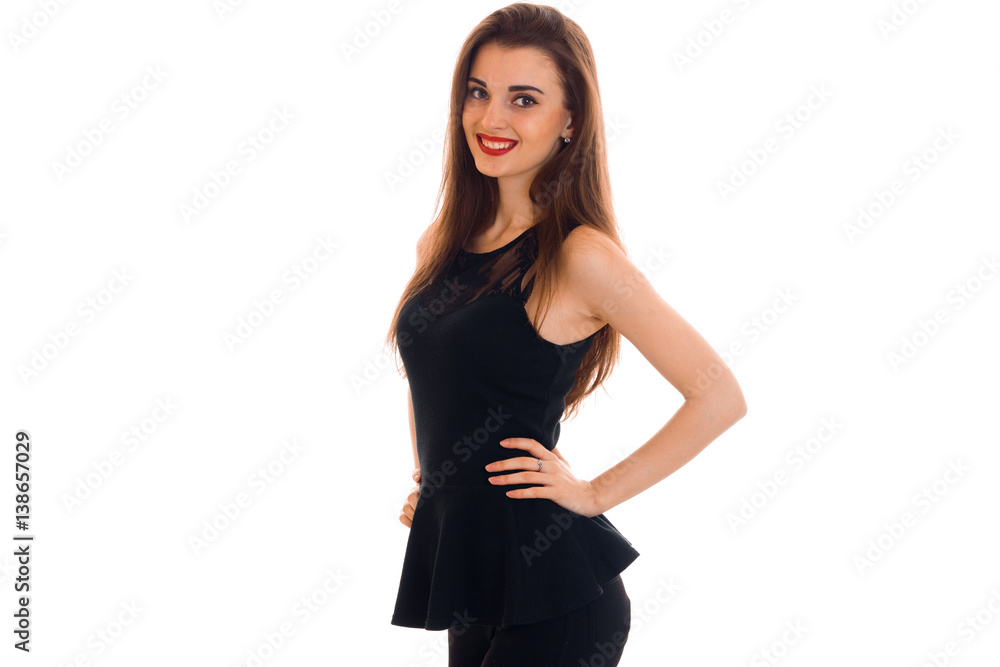 beautiful young girl in a black dress smiles and keeps a hand on the side