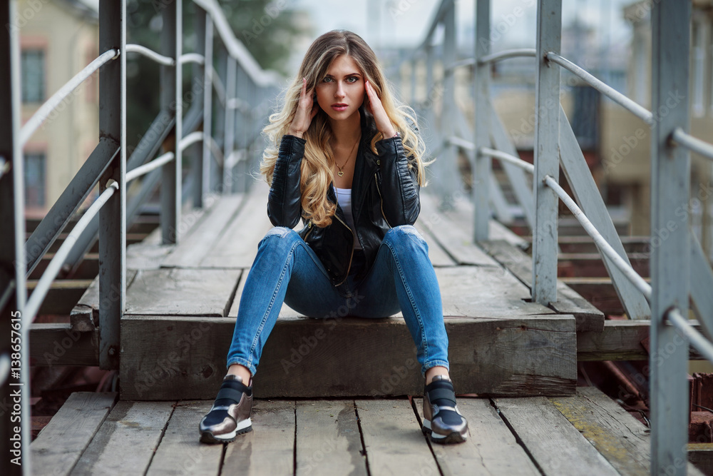 Outdoor lifestyle fashion portrait of pretty young girl wearing in hipster swag grunge style on urban background. Retro vintage toned image film simulation. Stock Adobe Stock