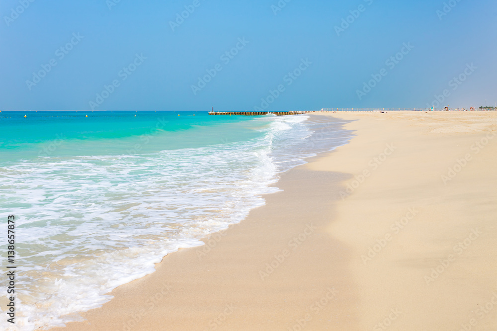 Panoramic view on nice Jumeirah beach in Dubai, UAE. United Arab Emirates famous tourist destination. Clear blue water Persian gulf, Indian Ocean