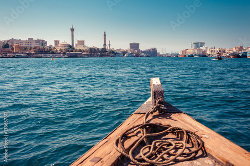 Panoramic view from traditional water taxi boats in Dubai, UAE. Creek gulf and Deira area. United Arab Emirates famous tourist destination. Creative color post processing.