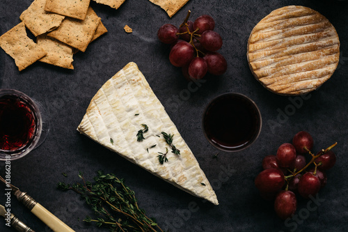 Horizontal Food Scene of Cheese, Grapes, Crackers and Red Wine on Rustic Table