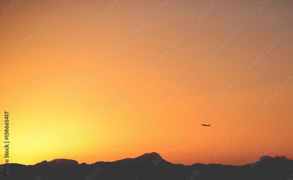 Airplane taking off at sunset