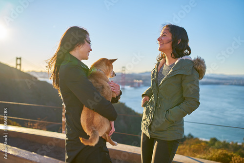 Photography same sex lesbian couple with pet dog shiba inu on hills in front of golden gate