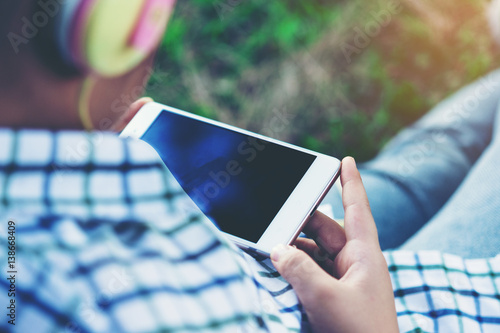 free happy cute girl enjoying. A beautiful kids hipster girl listening to music on headphones in the park.