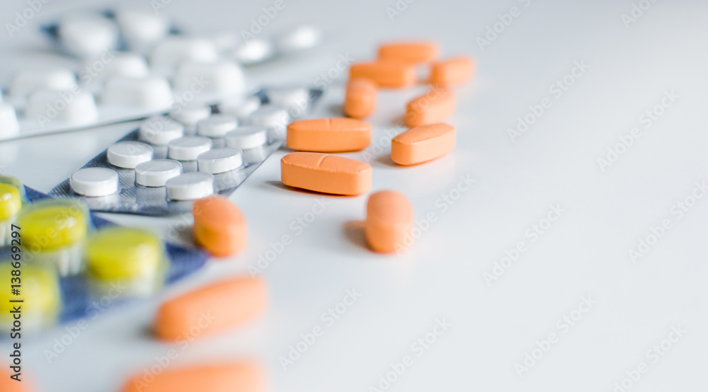 Pills in packages and unpackaged on a light background. Pills in packages and unpackaged on a light background.