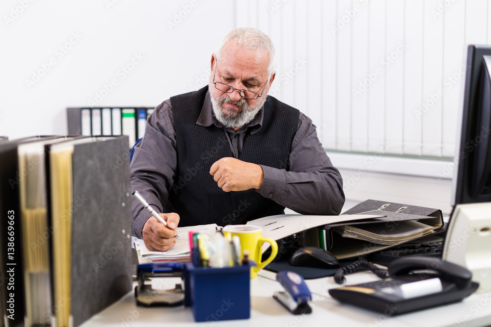 Mann am Schreibtisch mit Stress und Burnout