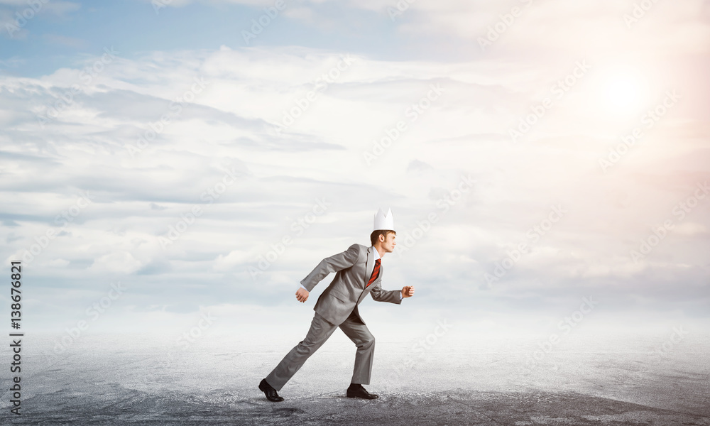 King businessman in elegant suit running and blue sky at background King businessman in elegant suit running and blue sky at background