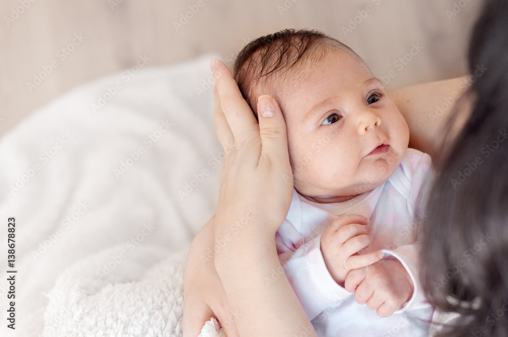 Mother with her newborn baby. Mother is holding her little baby girl.  Photo with the effect of sunlight, soft natural light, with selective focus.
