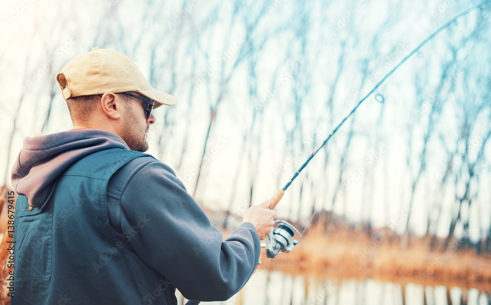 Young angler enjoys in fishing on the river. Sport, recreation, lifestyle Young angler enjoys in fishing on the river. Sport, recreation, lifestyle
